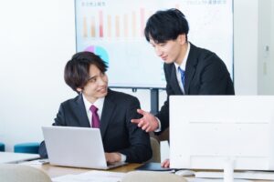 パソコンの前で話す二人
